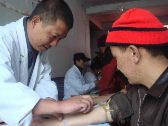 Исследователи берут пробы крови у тибетца, чтобы проанализировать его ДНК (фото Beijing Genomics Institute (BGI-Shenzhen)).